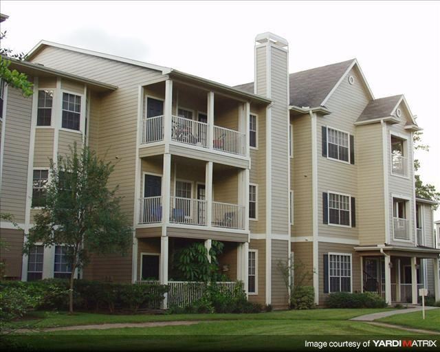 an apartment building with balconies and a lawn