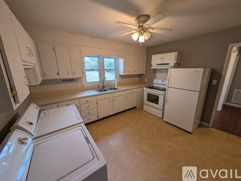 A kitchen with white appliances and wooden cabinets.
