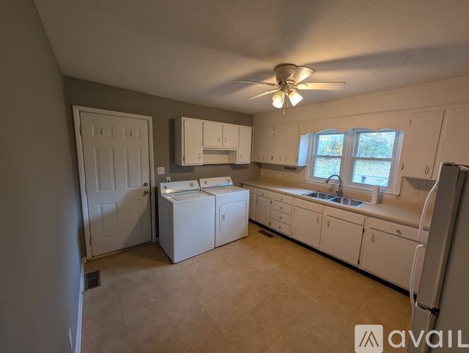 A kitchen with white appliances and cabinets.