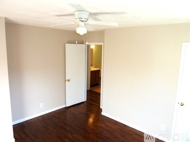A room with wooden floors and a window with blinds.