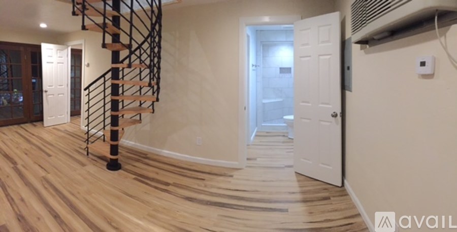 A room with a wooden floor and a spiral staircase.