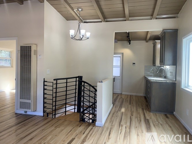 A kitchen area with a staircase and a sink.