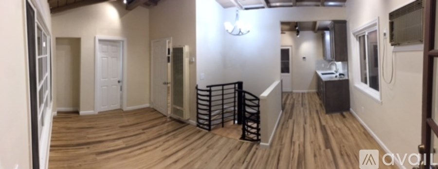 A wooden floor spans the length of a large, empty room.