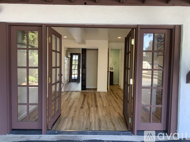 A house entrance with a glass door and a wooden floor.