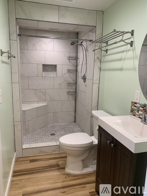 A white toilet is in a bathroom with a walk-in shower.