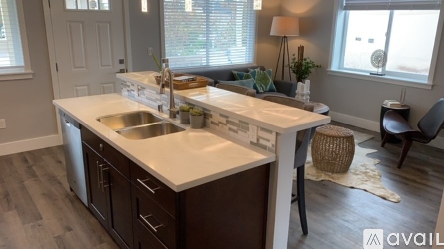 A modern kitchen with a white countertop and dark brown cabinets.