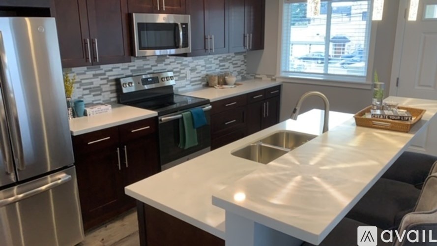 A kitchen with a stainless steel refrigerator and a white countertop.