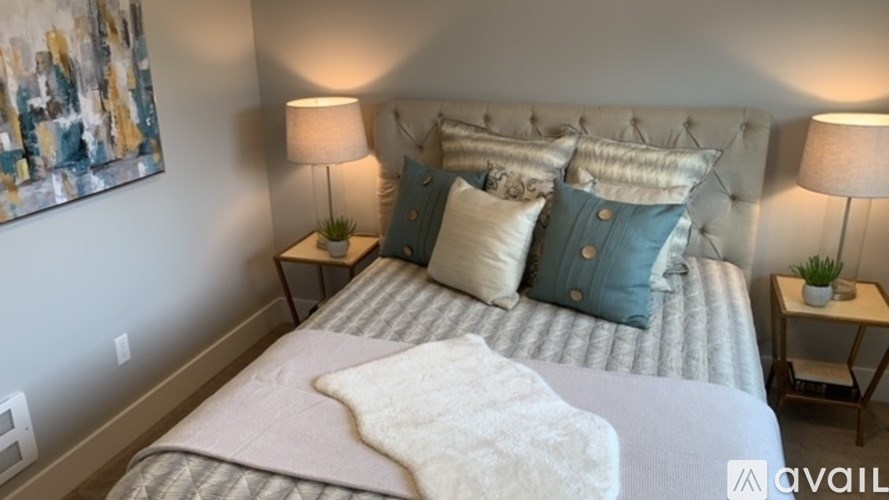 A bed with a white blanket and blue pillows is in the image.