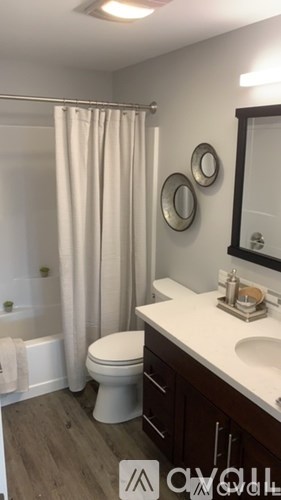 A white toilet sits in a bathroom next to a sink.