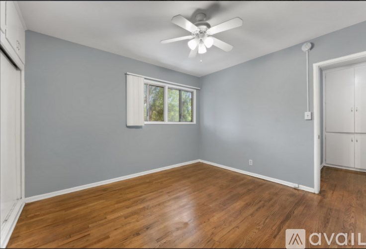A room with a ceiling fan and a window.