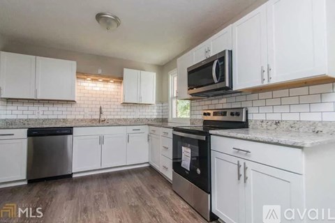 A kitchen with white cabinets and a black microwave above the stove.