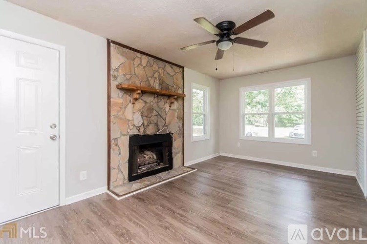 A room with a fireplace and a fan on the ceiling.
