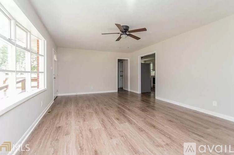 A room with a ceiling fan and wooden flooring.