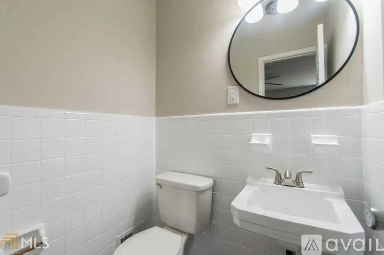 A bathroom with a toilet, sink, and mirror.