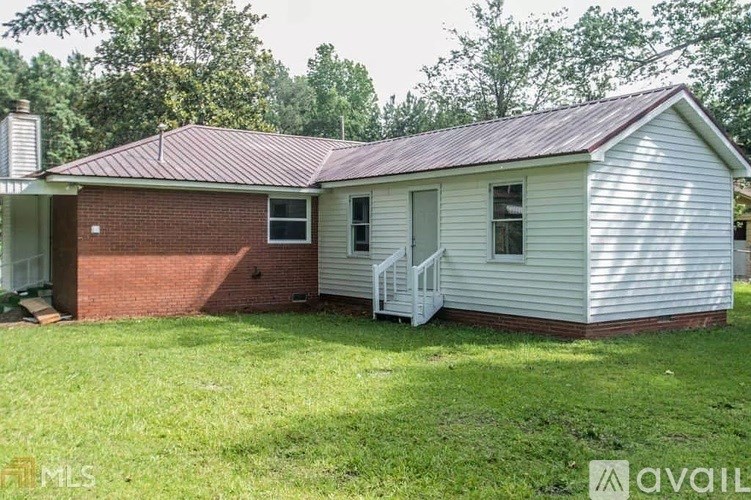 A house with a red roof and a white exterior is for sale.