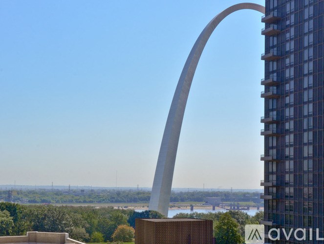 A tall arch structure stands in front of a building.