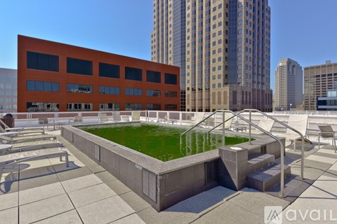 A rooftop garden with a pool and a building in the background.