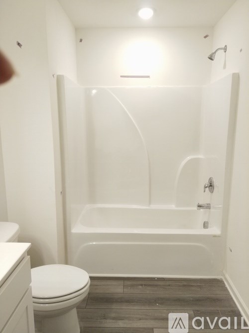 A white toilet sits next to a white bathtub in a bathroom.