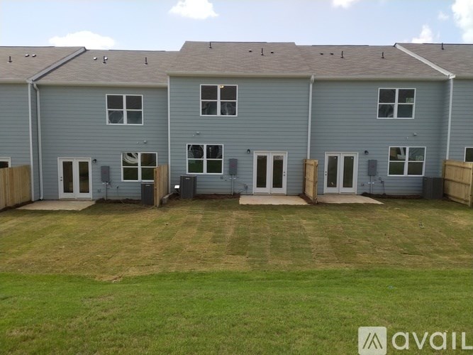 A grey house with a lawn in front.