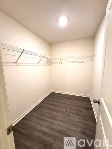 A hallway with a wooden floor and white walls.