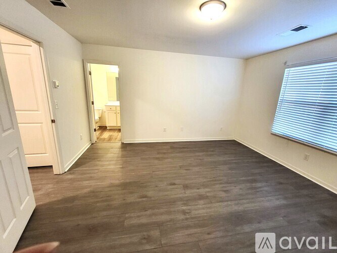 A room with wooden flooring and a mirror on the wall.