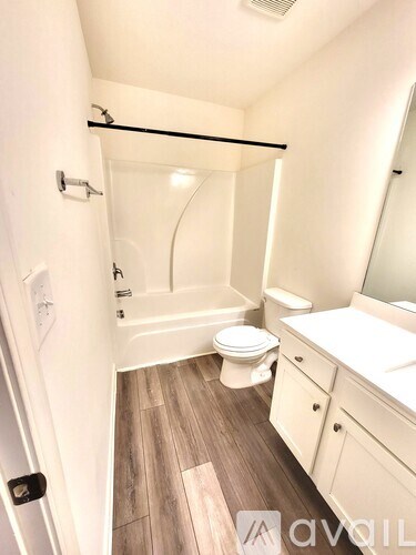 A bathroom with a toilet, sink, and shower.