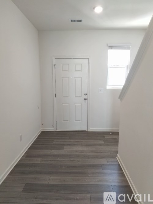 A room with a white door and a window.