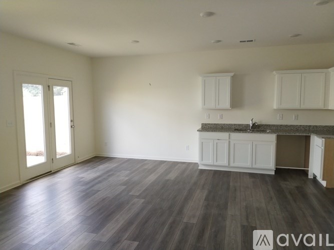 A kitchen area with white cabinets and a countertop is available.