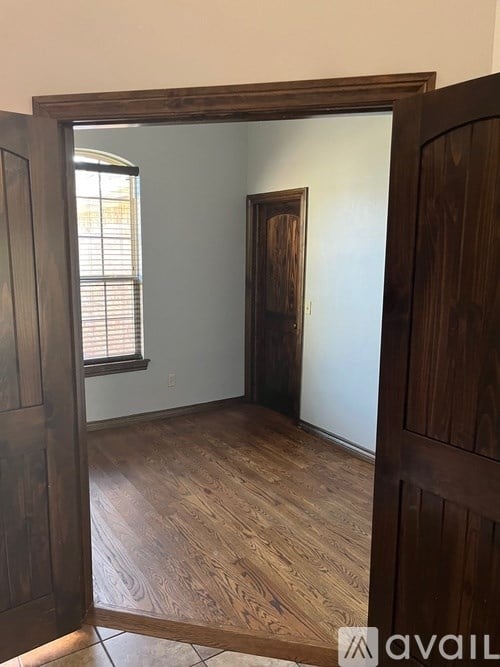 A room with wooden floors and a wooden door.