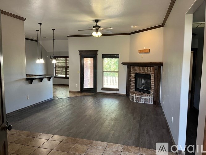 A living room with a fireplace and a ceiling fan.