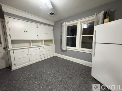 A kitchen with white cabinets and a window.