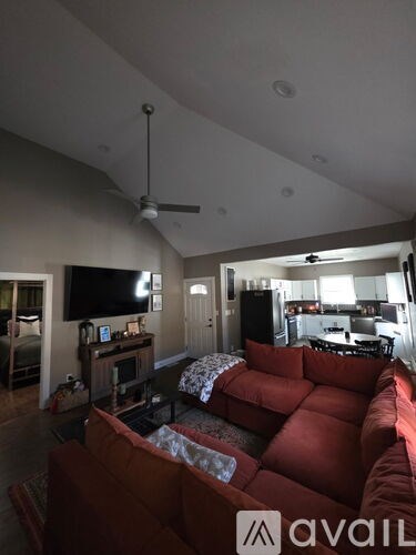 A living room with a red couch and a television.
