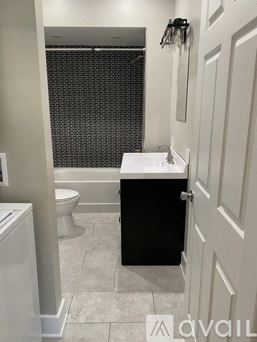 A bathroom with a toilet, sink, and shower.