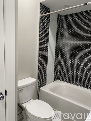 A white toilet sits next to a bathtub in a bathroom.