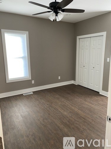 A room with a ceiling fan and a door.