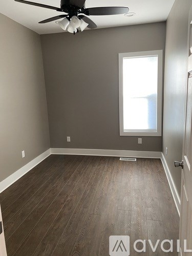 A room with a ceiling fan and a window.