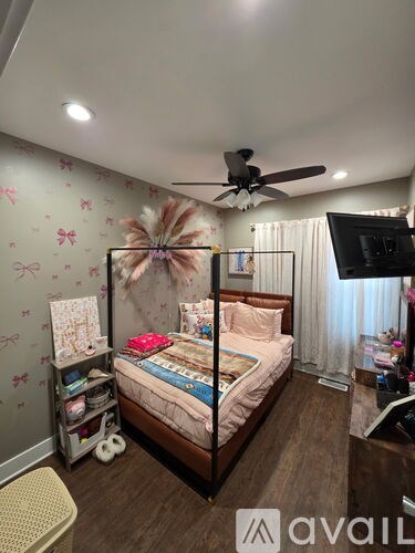 A bedroom with a bed, a ceiling fan, and a wallpapered wall.