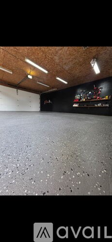 A spacious room with a black floor and a black wall with a mural.