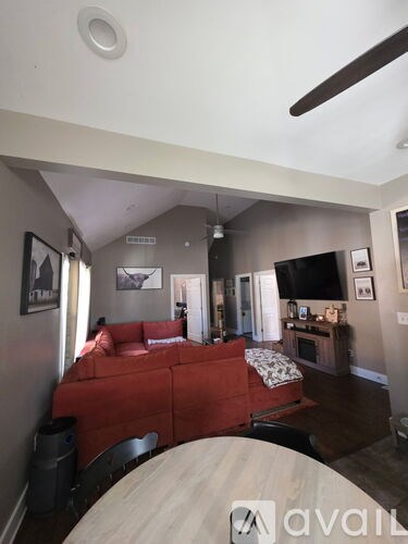 A living room with a red couch and a television.