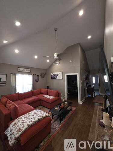 A living room with a red couch and a black coffee table.