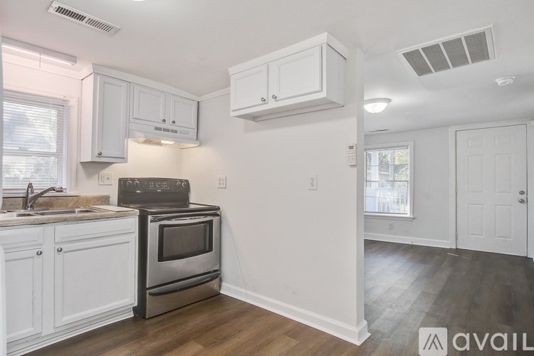 A kitchen with white cabinets and a stainless steel oven.