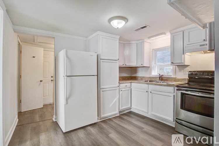 A kitchen with white appliances and cabinets.