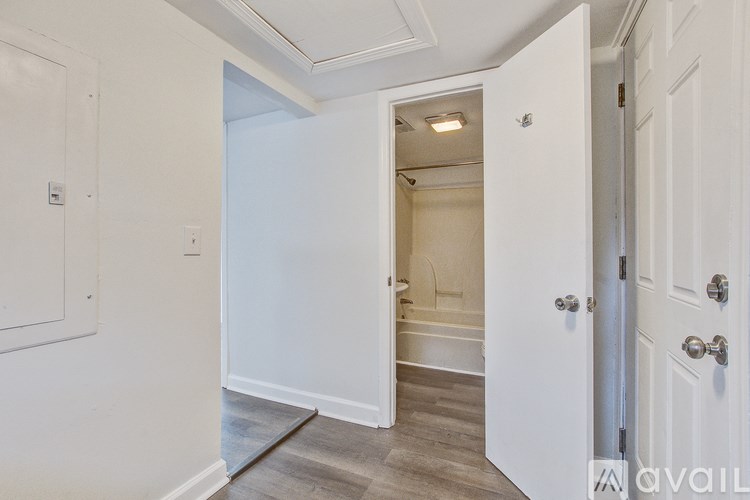 A white door is open to a bathroom.