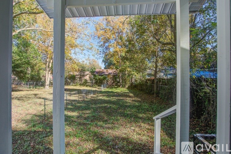 A view from a porch looking out to a yard with trees.