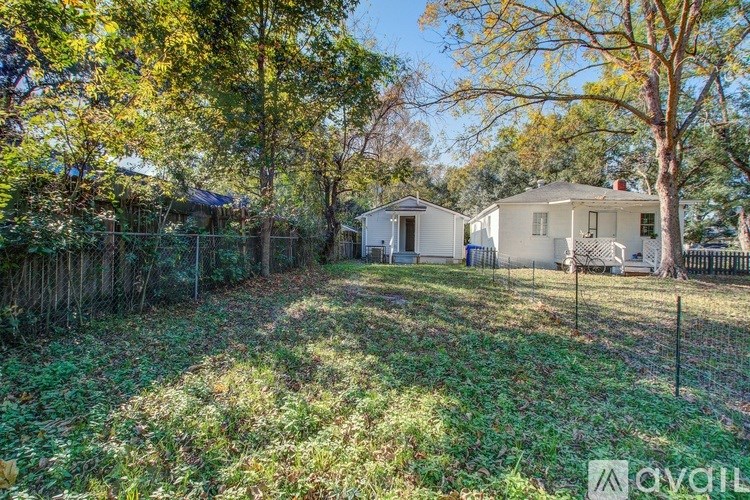 A backyard with a fence and two houses.