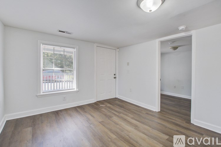 A room with a window and wooden flooring is available for rent.