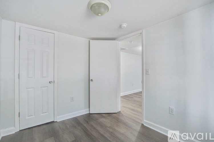 A room with a white door and a white ceiling light.