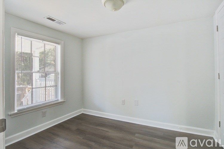 A room with a window and wooden flooring.