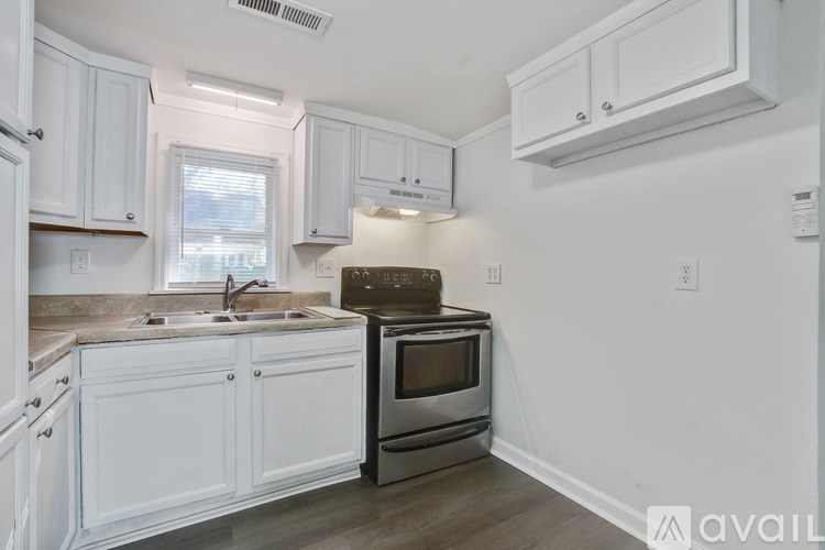 A kitchen with white cabinets and a stainless steel oven.