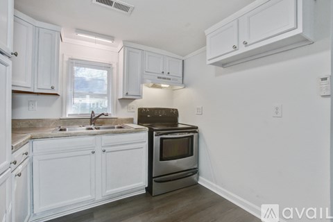 A kitchen with white cabinets and a stainless steel oven.